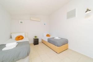 two beds in a room with white walls at Residence w Terrace Garden 15 min to Belek Beach in Belek