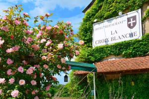 a sign on the side of a building with flowers at Auberge La Croix Blanche in Combreux