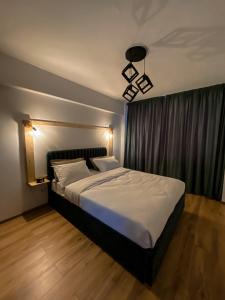 a bedroom with a large bed with white sheets at Central Station Two-Bedroom Family Apartment in Timişoara