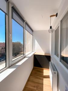 an empty room with large windows and a desk at Central Station Two-Bedroom Family Apartment in Timişoara