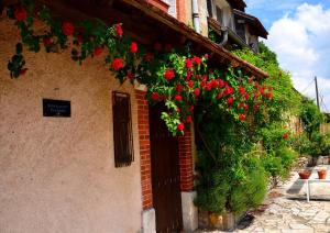a building with red flowers on the side of it at Auberge La Croix Blanche in Combreux
