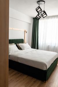 a bedroom with a large bed with a green curtain at Central Station Two-Bedroom Family Apartment in Timişoara