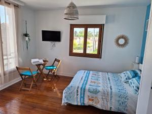 una camera da letto con un letto, un tavolo e delle sedie di La Maison Partagée d'Arlac a Mérignac