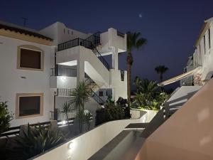 una gran casa blanca con escaleras y plantas por la noche en Casa Palmera, en Palomares