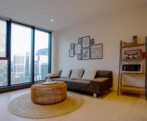 a living room with a couch and a table at Cozy & spacious 2B2B APT in CBD in Melbourne