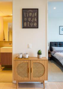 a bedroom with a bed and a wooden cabinet with a table at Cozy & spacious 2B2B APT in CBD in Melbourne