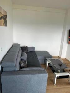 a living room with a blue couch and a table at Gastehaus Dollenz in Tiebitsch