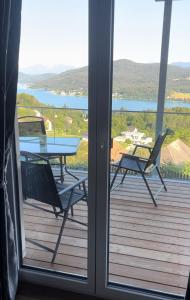 a table and chairs on a deck with a view of a lake at Gastehaus Dollenz in Tiebitsch