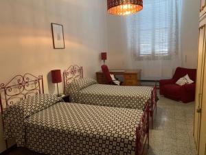 - une chambre avec deux lits, une chaise et un lustre dans l'établissement Casa Pucci, à Pietrasanta