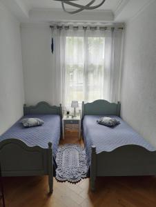 two beds in a room with a window at Esplanaadi Luxury Apartment in Pärnu