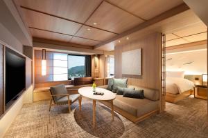 京都DoubleTree by Hilton Kyoto Higashiyama的一间卧室和一间带一张床及一张桌子的客厅