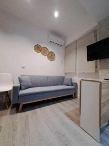 sala de estar con sofá azul y TV en ACC Serrano 1 aparcamiento cercano, en Jaén
