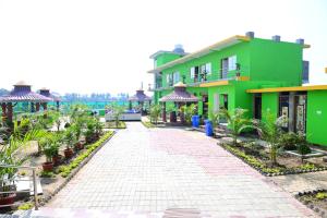 a cobblestone street in front of a green building at Jungle Avengers Resort Bhitarkanika in Righāgarh