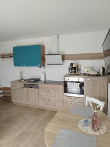a kitchen with wooden cabinets and a table with a table at Fewo Treichel in Ostseebad Koserow