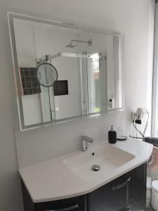 a bathroom with a sink and a large mirror at Fewo Treichel in Ostseebad Koserow