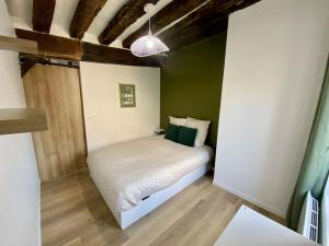a small bedroom with a bed in a room at L’Eucalyptus in Rouen