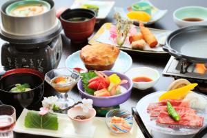 una mesa con platos de comida y tazones de comida en 湯元ホテル阿智川, en Komaba