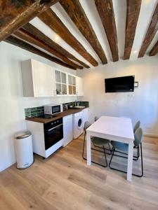 a kitchen with a white table and a table and chairs at L’Eucalyptus in Rouen