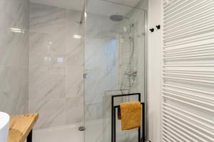 a shower with a glass door in a bathroom at Luxe strandappartement met zonneterras & parking in Koksijde +16 photos