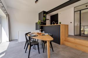 a kitchen and dining room with a wooden table and chairs at Luxe strandappartement met zonneterras & parking in Koksijde