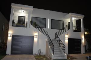 una casa bianca con una scala davanti di notte di Dimond Abode Vacation Rental #2 a Oakland