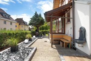 un patio con un banco en el lateral de una casa en die Bahnstation, en Friedrichshafen