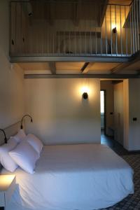 Affittacamere Valèt في San Marzano Oliveto: سرير بشرشف ووسائد بيضاء في الغرفة