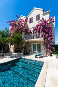une villa avec une piscine en face d'une maison dans l'établissement Deluxe apartment BRAČOLET private pool, à Supetar
