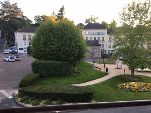 uma vista para um parque com uma rua e edifícios em Bristol Manor Bel apt F3 face aux thermes Néris em Néris-les-Bains