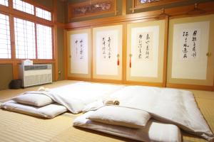 een groot bed in een kamer met een opschrift op de muur bij Guest House Gimanchi in Ashoro