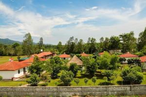 a group of houses with red roofs and trees at Wildlife Resort Jim Corbett in Kālāgarh