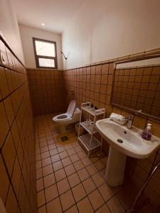 a bathroom with a sink and a toilet at شالية راقي بمسبح وجلسات خارجية in ‘Ilb