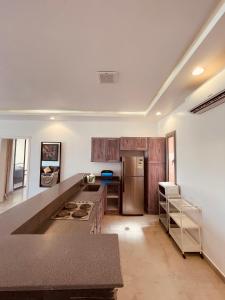 a kitchen with wooden cabinets and a stainless steel refrigerator at شالية راقي بمسبح وجلسات خارجية in ‘Ilb