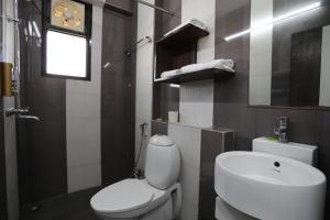 a bathroom with a white toilet and a sink at Banipark Service Apartment in Jaipur +35 photos