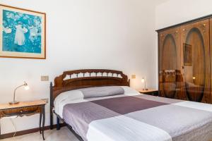 a bedroom with a large bed with a wooden headboard at Casa Luz in Giglio Porto