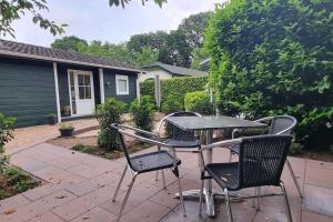 una mesa y sillas en un patio en Fijn chalet met grote tuin op de Veluwe en Epe