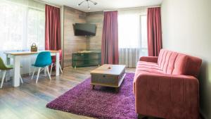 a living room with a pink couch and a table at The old Bakery Apartments in Plovdiv