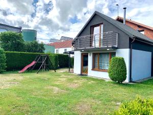 a house with a playground in the yard at Fonica - Domek Apartament in Łeba