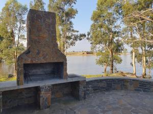 a brick fireplace with a view of a lake at Perdestal in Oranjeville