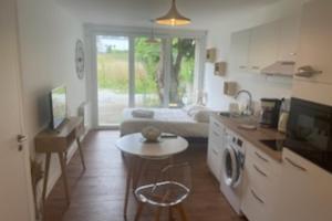 a kitchen and living room with a couch and a table at Le Jaures 1 - Studio - RDC in Hennebont