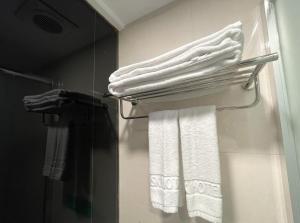 uma casa de banho com toalhas brancas num toalheiro em 西門雲町旅店 Sky Gate Hotel em Taipei