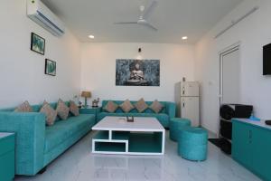 a living room with a blue couch and a table at BANIPARK SERVICE APARTMENT in Jaipur