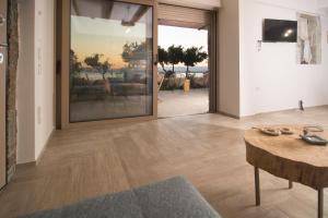 Wood&Stone Guesthouse في Almirón: غرفة معيشة مع طاولة وباب زجاجي كبير
