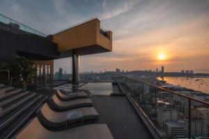 a view of a sunset from a building with benches at Edge Central Pattaya BJ 88 in Pattaya Central