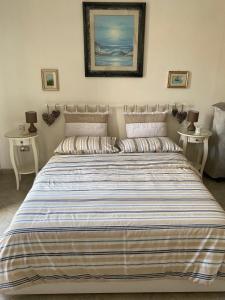 una camera da letto con un grande letto con due tavoli di Casa Bella Vista a Morciano di Leuca