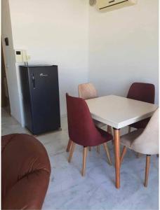 a table and chairs in a room with a refrigerator at Panamera vue mer 180 degré in Sousse