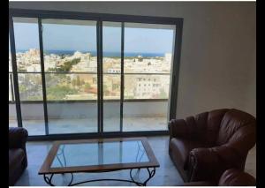 uma sala de estar com um sofá e uma mesa de vidro em Panamera vue mer 180 degré em Sousse