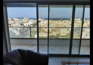 a view of a city from a large window at Panamera vue mer 180 degré in Sousse