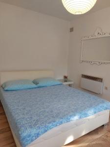 Schlafzimmer mit einem Bett mit blauer Decke in der Unterkunft Apartmani Neda in Čitluk