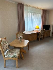 Zimmer mit einem Schreibtisch, einem Tisch und Stühlen in der Unterkunft In & Out Boardinghaus in Stolberg